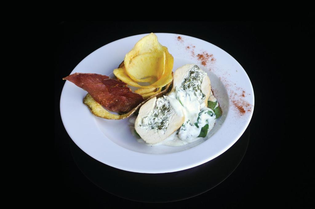 a white plate of food with eggs and bacon at Evidencia Belverde Hotel in Amora