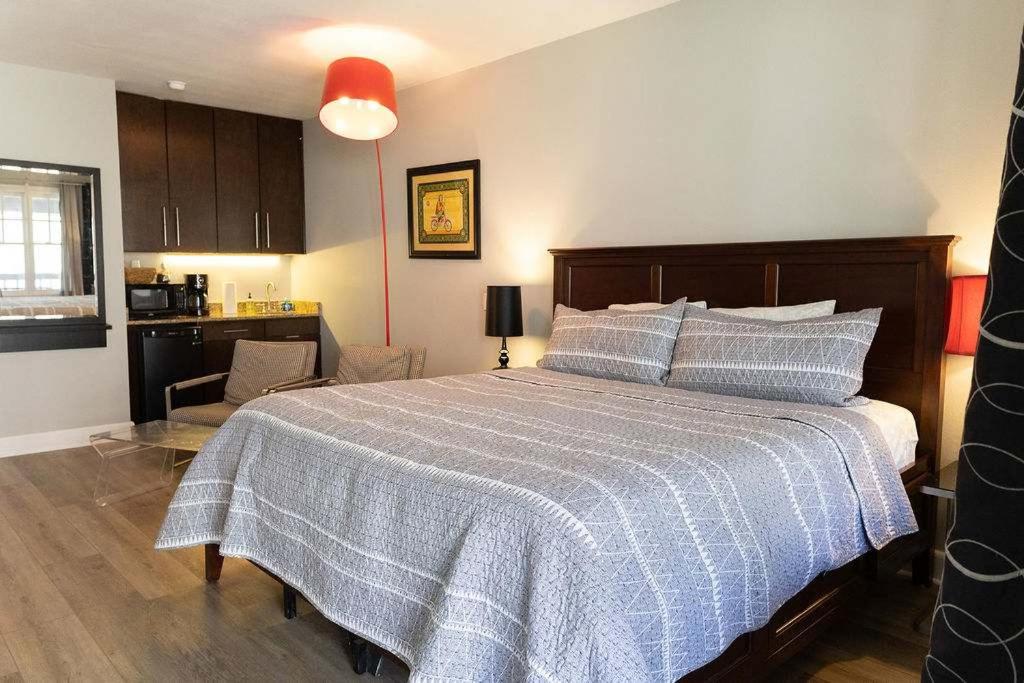 a bedroom with a large bed and a kitchen at Bella Paradiso 13 King Bed Studio Walk to Downton in Eureka Springs
