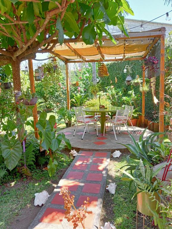 a patio with a table and chairs under a pergola at Casa HecAny in Catemaco