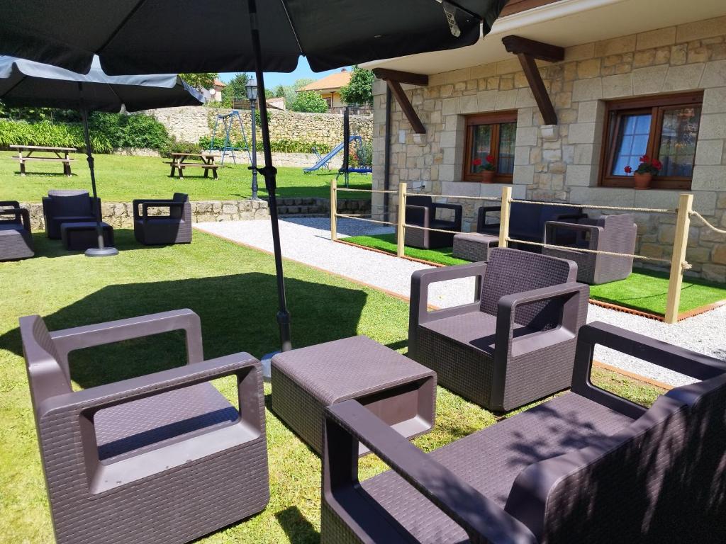 Un grupo de sillas y sombrillas en un patio. en Apartamentos Altamira, en Santillana del Mar
