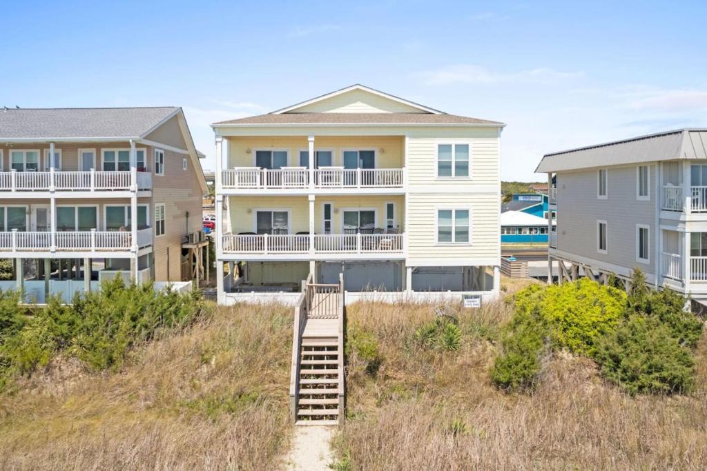 ein Haus am Strand mit einer Treppe davor in der Unterkunft Hypnotic your seaside retreat in Holden Beach