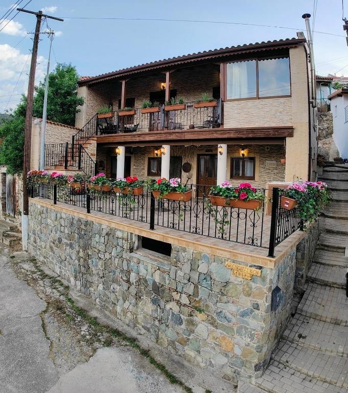 a house with flowers on a stone wall at Archontikon 1817 in Kaliana