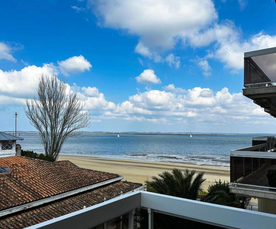 une vue sur la plage depuis le balcon d'un immeuble dans l'établissement Résidence Heliodore - Arcachon - Charmant T2 en bord de plage MAE-9114, à Arcachon
