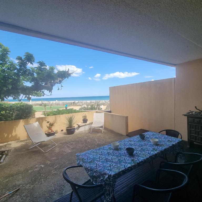 une pièce avec une table et des chaises et une grande fenêtre dans l'établissement EMPLACEMENT EXCEPTIONNEL,FRONT DE MER, Appt 4 couchages, RDC, Allée des Arts, au Barcarès