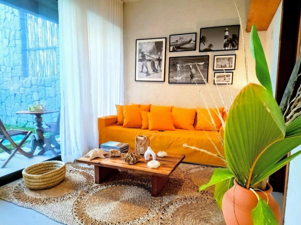 un soggiorno con un divano arancione e un tavolo di Casa Arcanjo - Patacho a Pôrto de Pedras