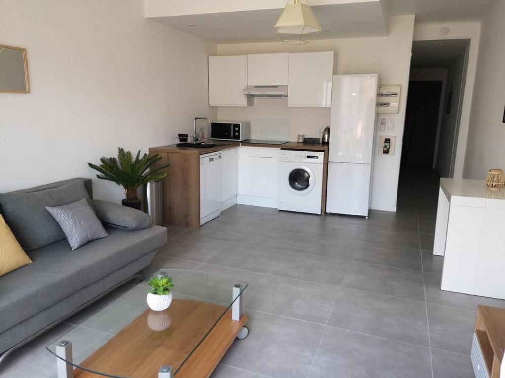 une cuisine et un salon avec un canapé et une table dans l'établissement Charmant 2P au cœur de Juan-les-Pins, à Juan-les-Pins