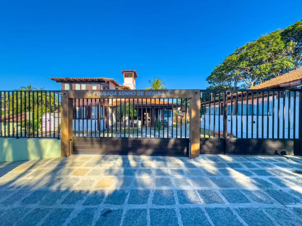 a wooden gate in front of a house at Pousada Sonho de Geribá in Búzios