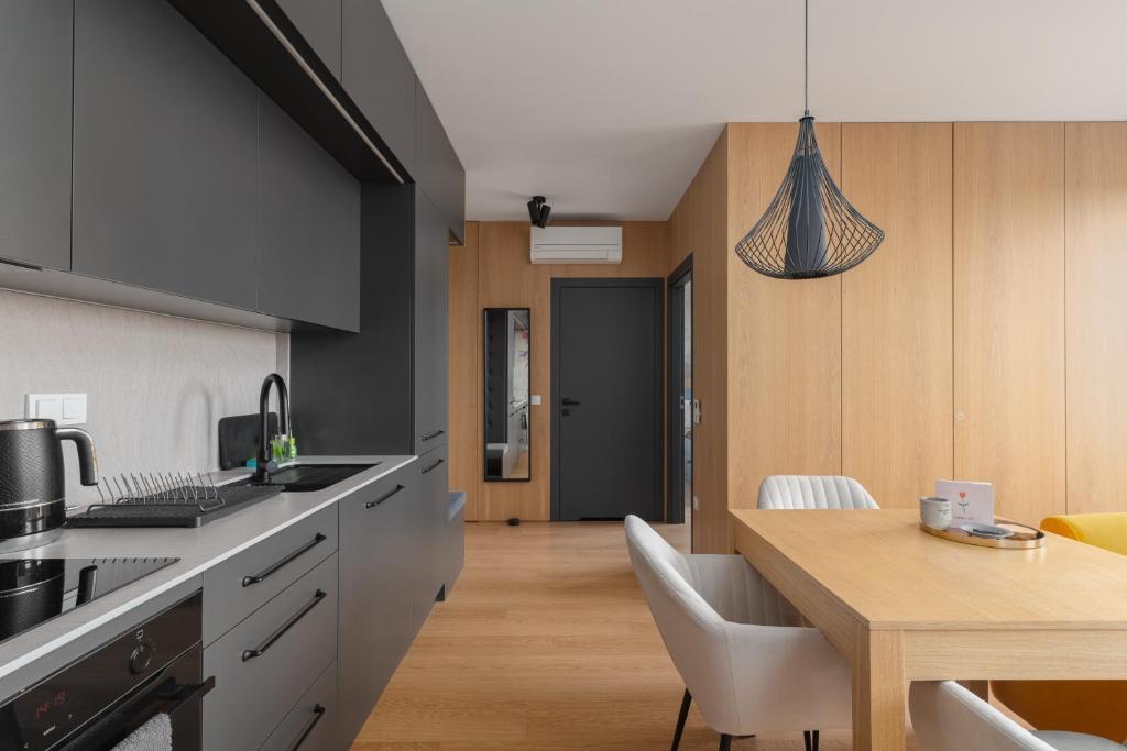 a kitchen with a table and a dining room at Fuzja w Chmurach - parking, klimatyzacja by FusionAparts in Łódź