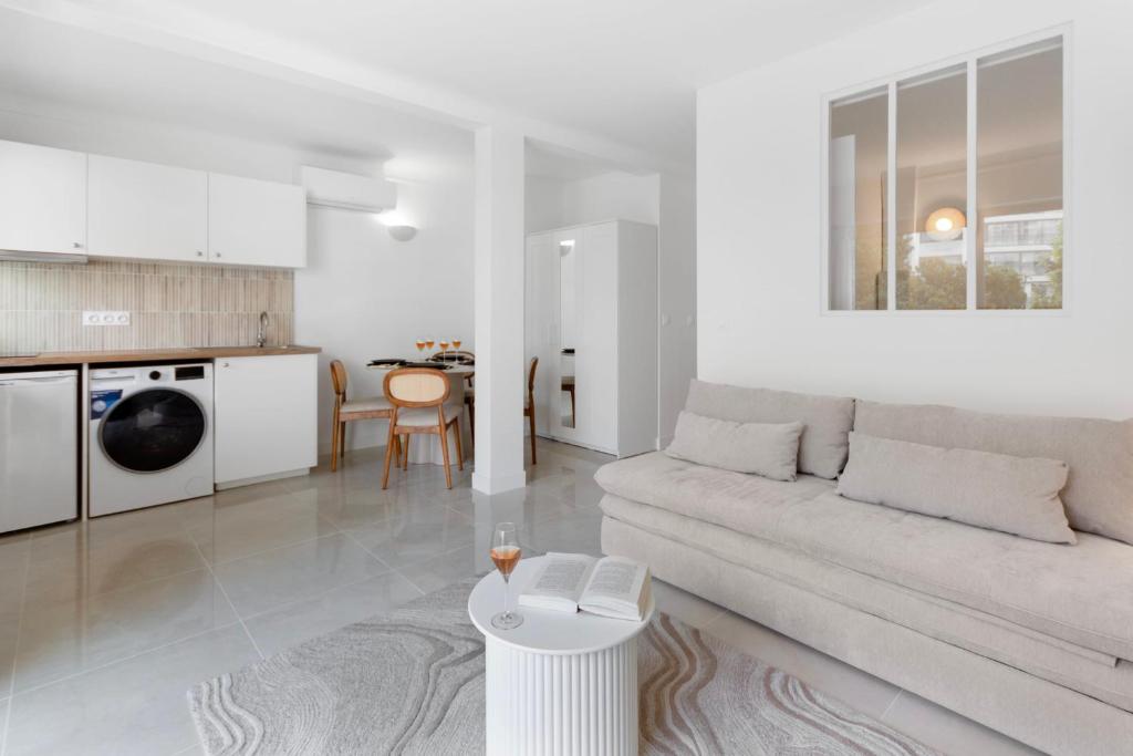 un salon blanc avec un canapé et une table dans l'établissement Le Palais - Hypercentre - Croisette - Calm - AC, à Cannes