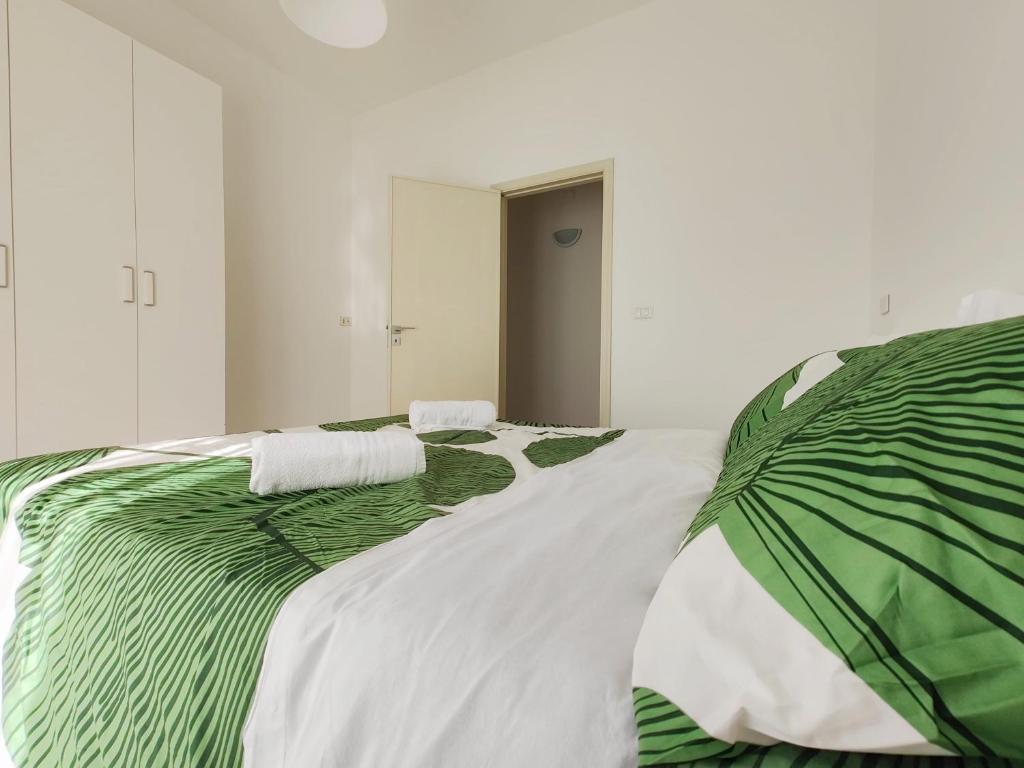 un letto verde e bianco con due cuscini sopra di Lemon Tree Home ad Aci Castello