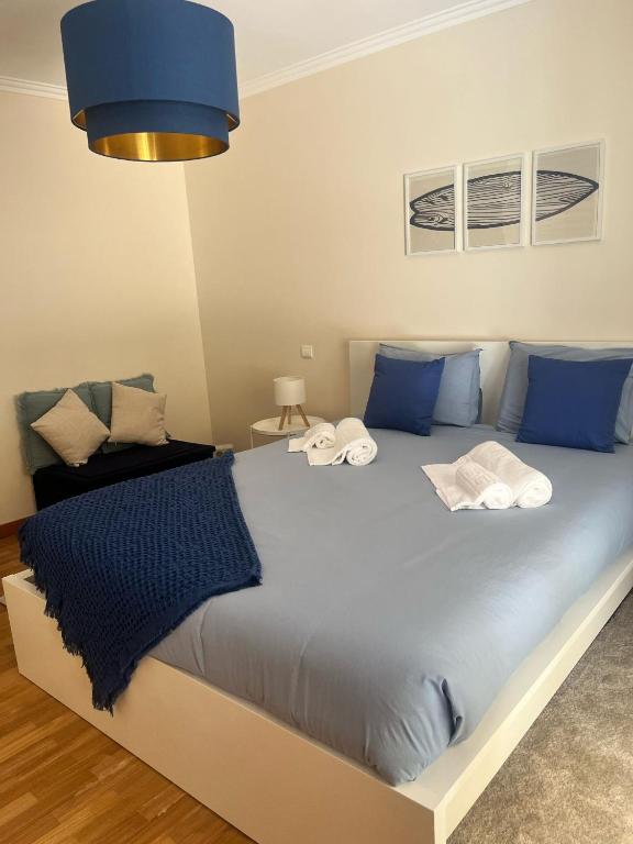 a bedroom with a large bed with blue pillows at Sea and Nature Escape in Furadouro