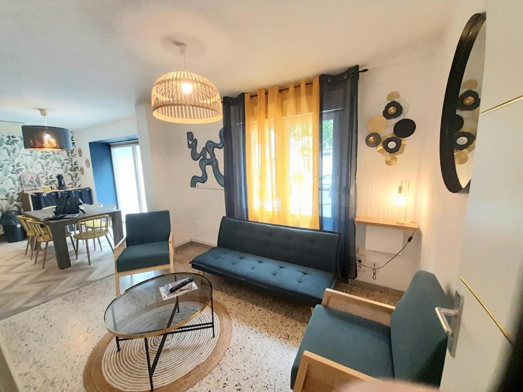 un salon avec un canapé et une table dans l'établissement Maison de village rénovée au pied des alpilles, à Mollégès