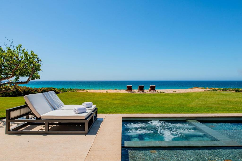 a pool with a lounge chair next to the ocean at West Enclave 7 by Cabo Villas in San José del Cabo