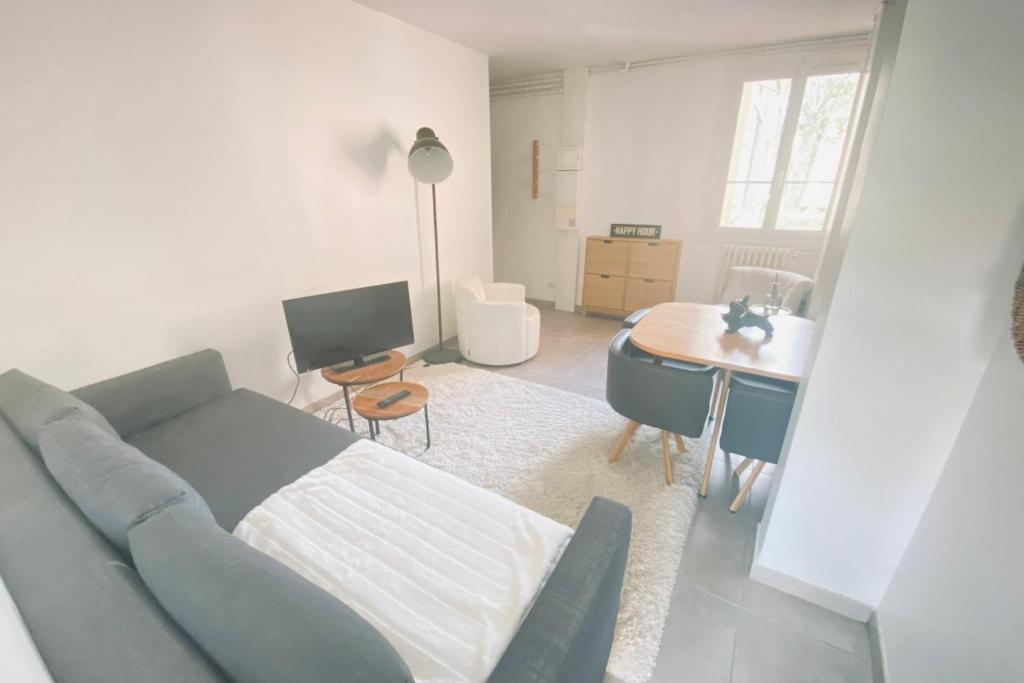 - un salon avec un canapé bleu et un bureau dans l'établissement Bright 2-bedroom apartment, à Toulouse
