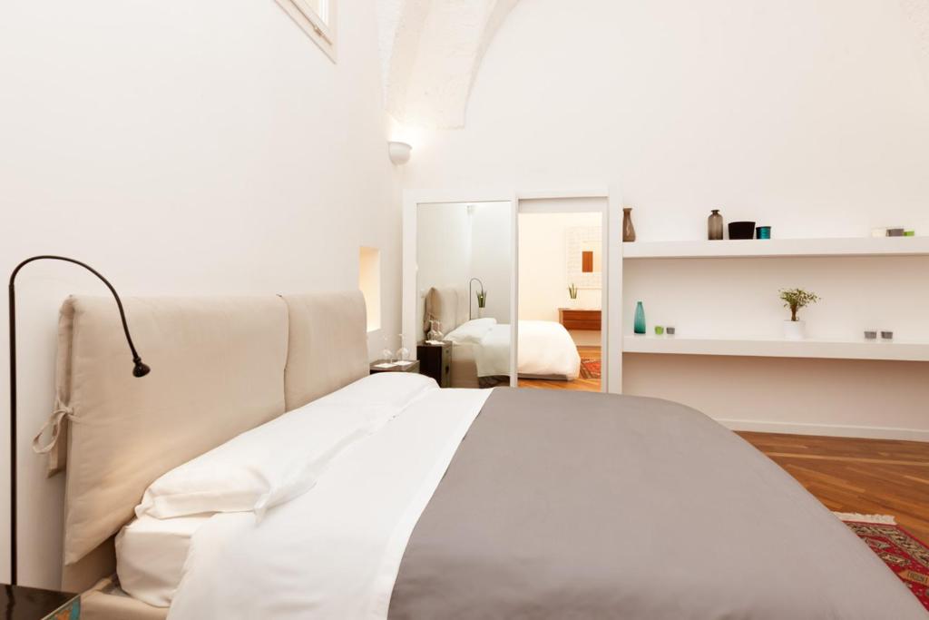 a bedroom with a white bed and a white room at San Matteo House in Lecce