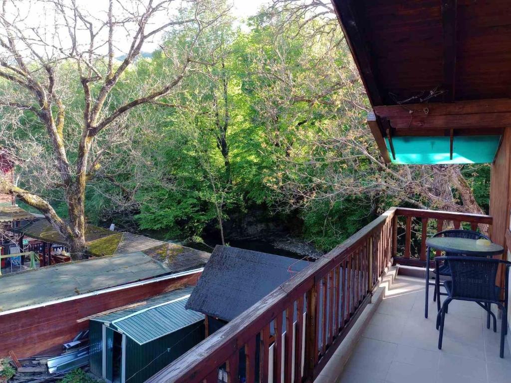 a balcony of a cabin with a table and chairs at Riverlyn Guest House in Ribarica