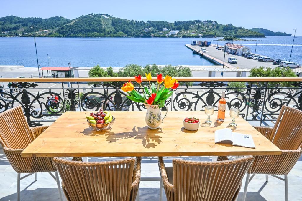 a wooden table with flowers on top of a balcony at Nisaki House in Skiathos