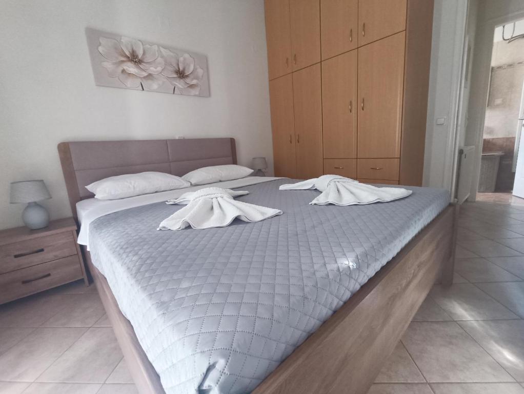 Una cama con sábanas blancas y toallas. en Marys Homes, en Lefkada