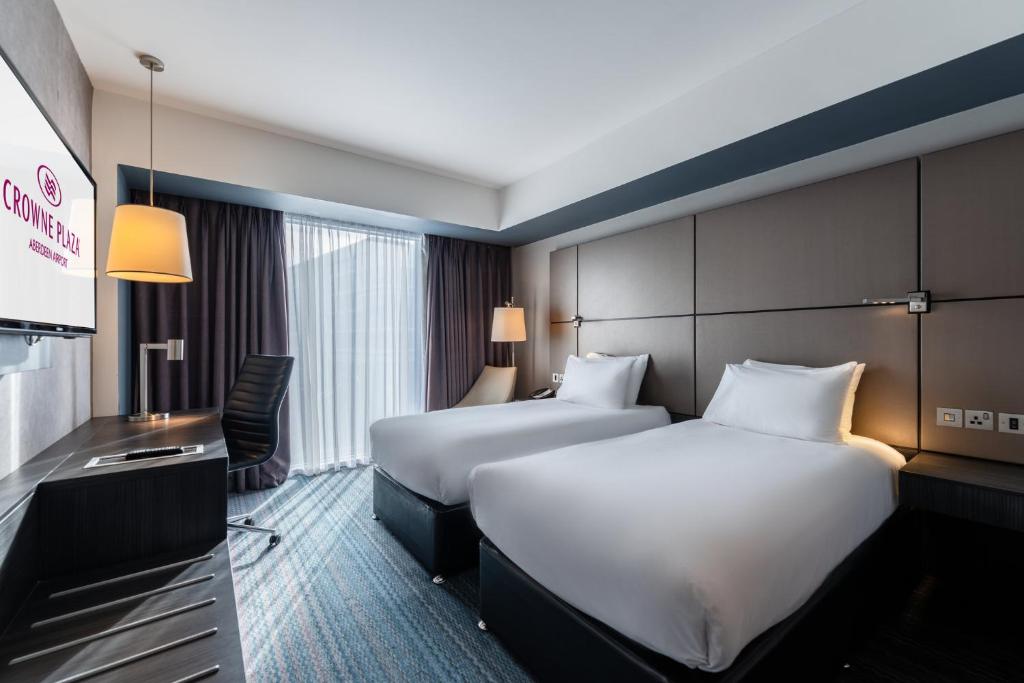 a hotel room with two beds and a television at Crowne Plaza Aberdeen Airport by IHG in Dyce