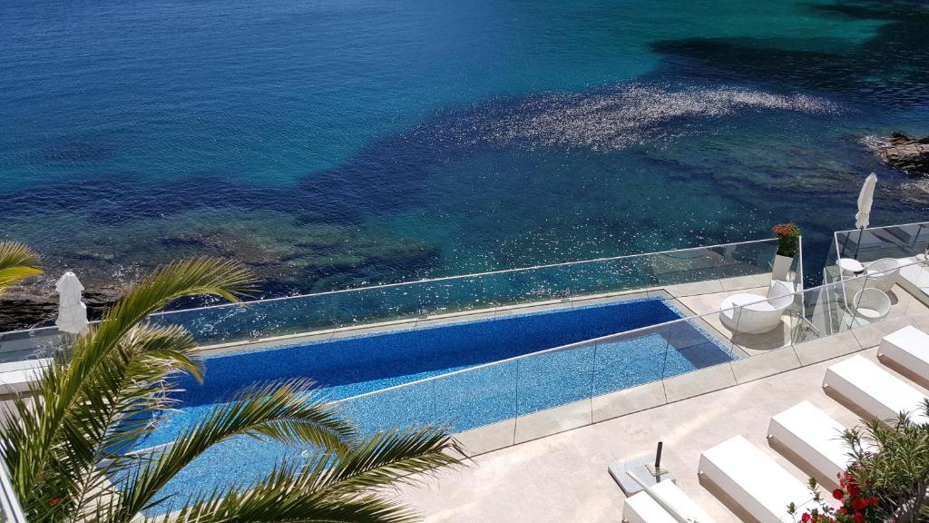 uma vista superior de uma piscina ao lado do oceano em Hotel La Calanque em Cavalaire-sur-Mer