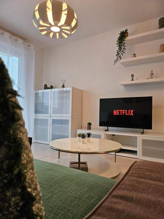 un salon avec une télévision et une table dans l'établissement Charming apartment between beach and center of Juan-les-Pins, à Antibes