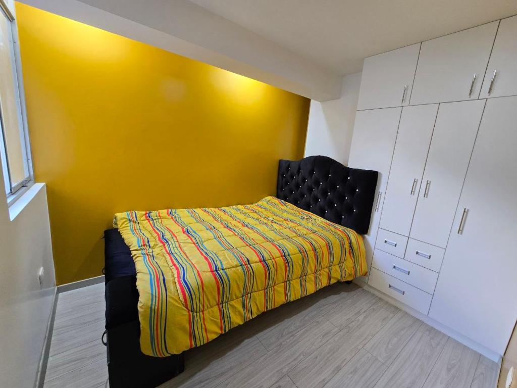 Abancayにある401 Moderno departamento equipadoのベッドルーム1室(黄色い壁のベッド1台付)