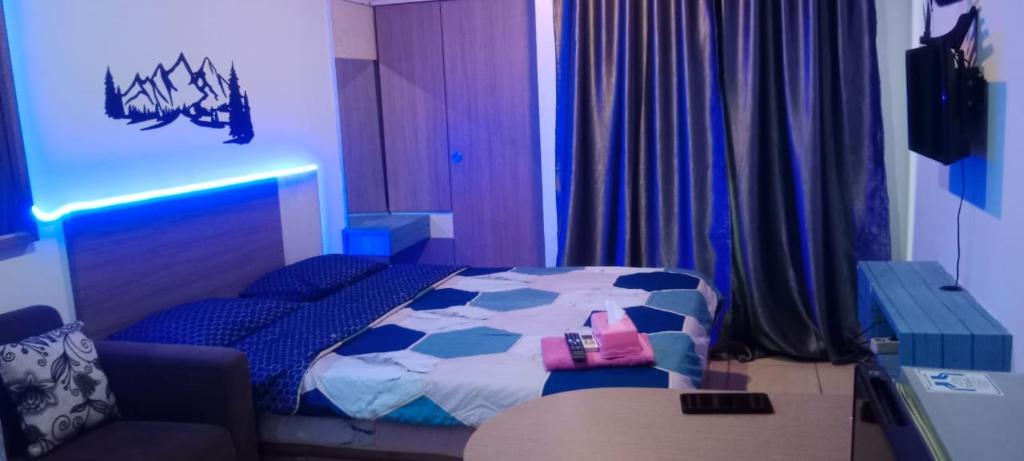 a bedroom with a bed and a blue light at Apartemen paragon village in Peusar Dua