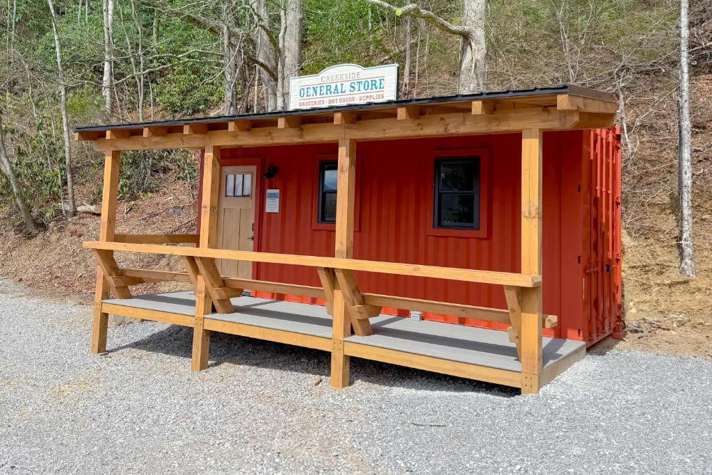 a red cabin with a sign on top of it at Farmhouse Tiny home with fishing Pond - Oak Cabin in Gatlinburg