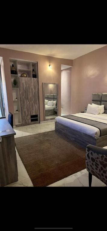 a large bedroom with a bed and a mirror at La VOD Hotel in Benin City
