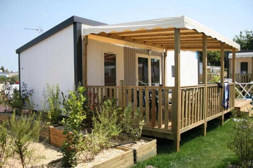 une petite maison avec une terrasse à baldaquin dans l'établissement Camping 3 étoiles - Parc aquatique - eecfea, à Saint-Maime