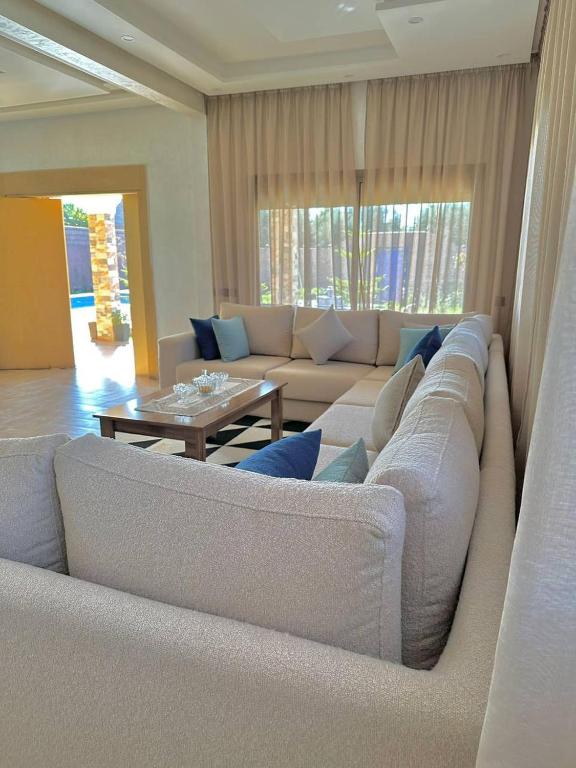 a living room with a couch and a table at Villa - Dar Tura in Tikoutar