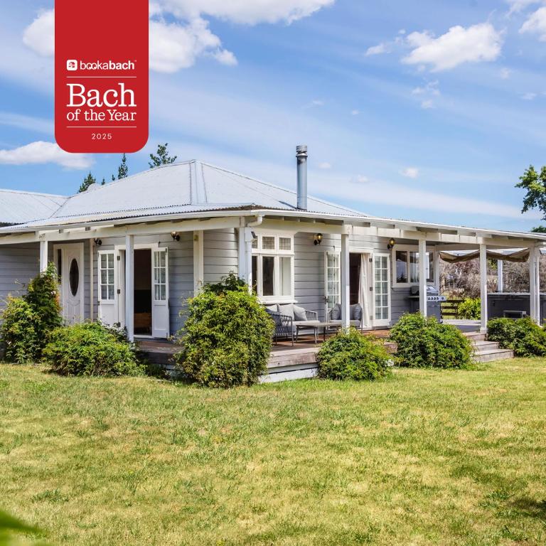 a white house with a porch and lawn at Brooklands Cottage The Award Winning Villa in Martinborough