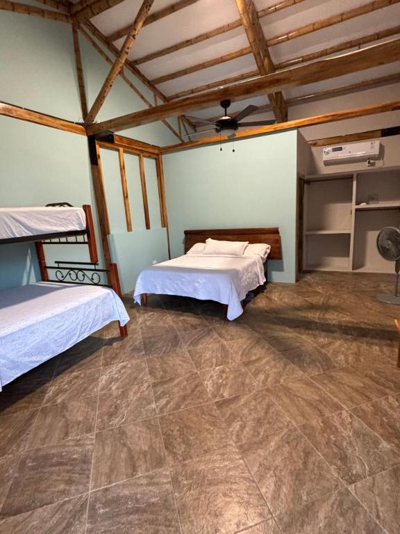 a bedroom with two beds and a tiled floor at Sirena's Beach & Surf Club in Canoa