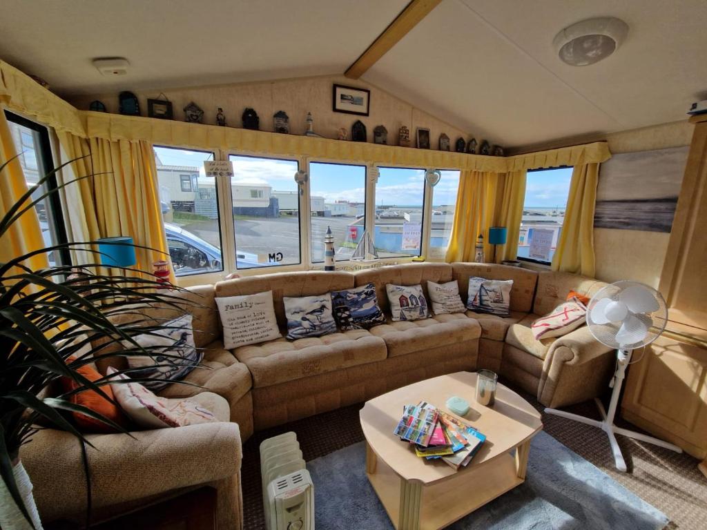 a living room with a couch and a table at Sea View Escape 2 Bedroom Pet Friendly Caravan at Clarach Bay Gm3 in Aberystwyth