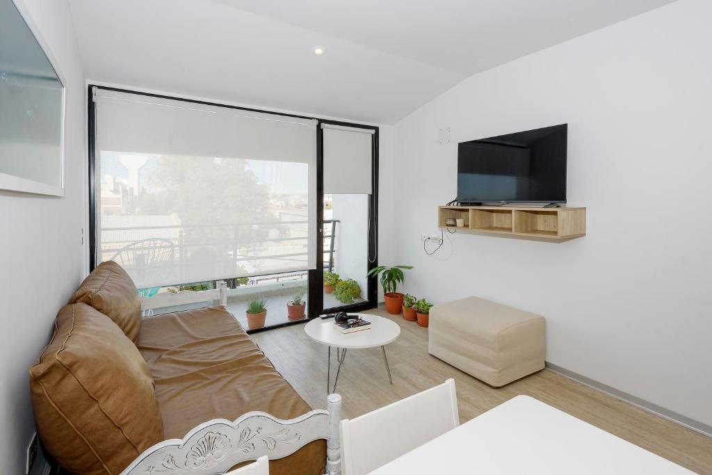 a living room with a couch and a flat screen tv at Mioceno in Puerto Madryn