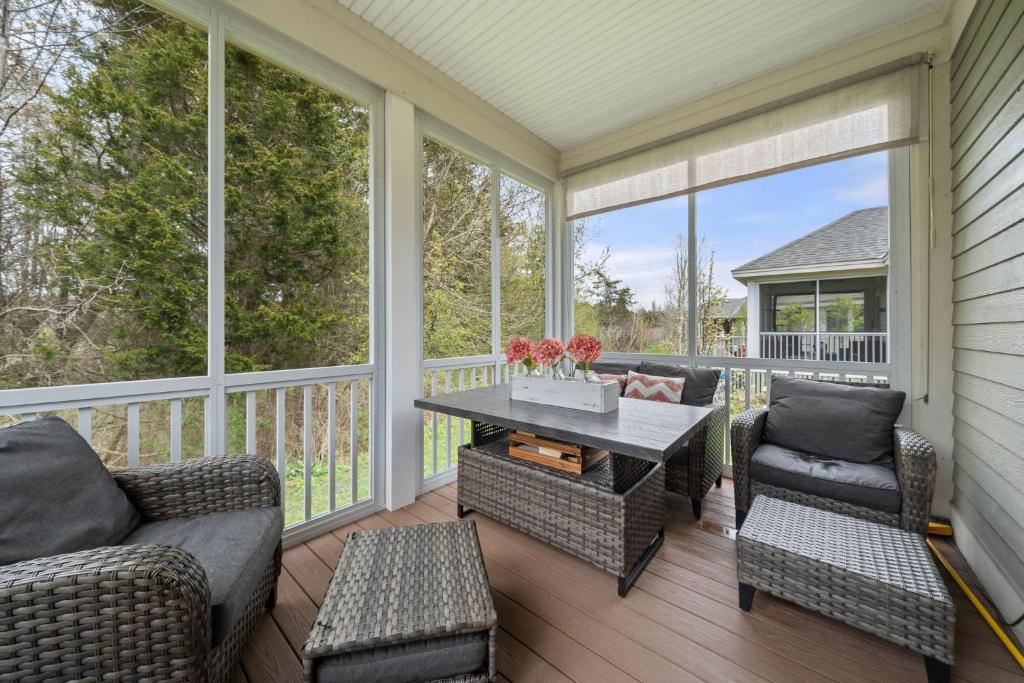 a screened porch with a table and chairs at Le Wapiti - 75 Butternut in Cherry Valley