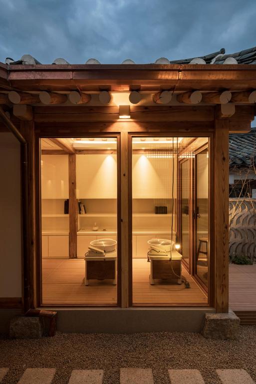 ein Zimmer mit einem Glasfenster mit einer Terrasse in der Unterkunft Nostalgia Hanok Hotel in Seoul