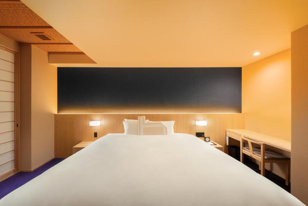 Postel nebo postele na pokoji v ubytování Homm Stay Nagi Shijo Kyoto By Banyan Group