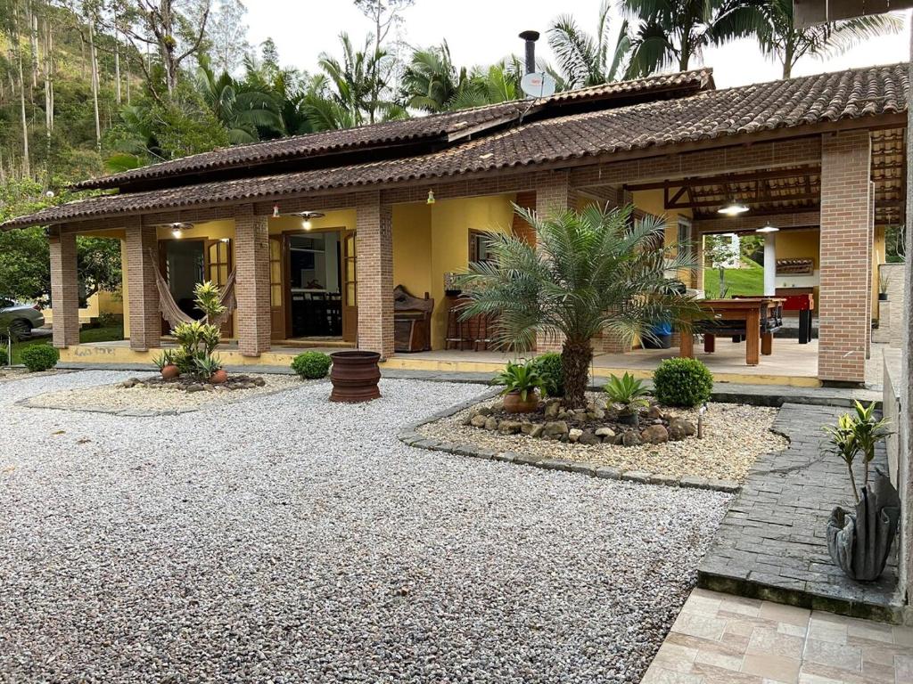 Una casa con un camino de entrada de grava en frente de ella en Chácara do Paulo, en Santo Amaro da Imperatriz
