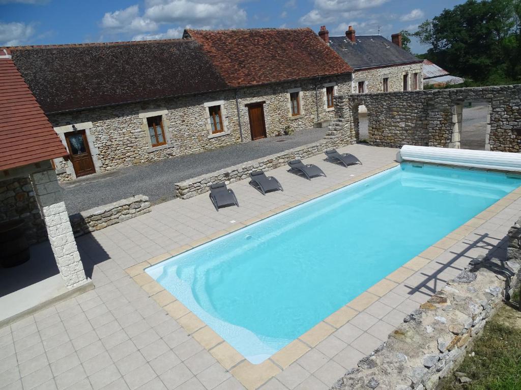 una grande piscina davanti a una casa di Charmant Gîte en Brenne avec Jardin, Piscine Partagée et Proximité Sentiers de Randonnée - FR-1-591-99 a Prissac