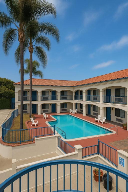 Una vista de la piscina en un resort con palmeras. en LYFE INN &amp; SUITES by AGA - LAX Airport, en Inglewood