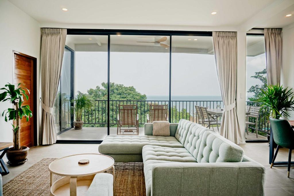 a living room with a couch and a large window at Blue Horizon Haad Yao, Seaview 3BR Apartment in Haad Yao
