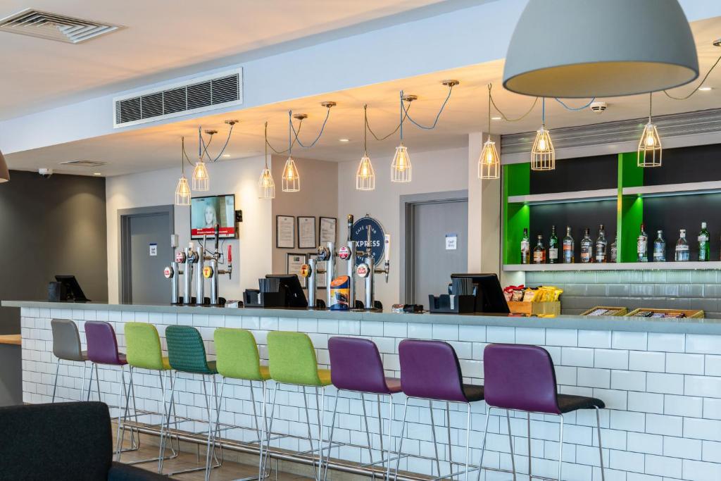 a bar with purple and green chairs at Holiday Inn Express Aberdeen Airport by IHG in Dyce