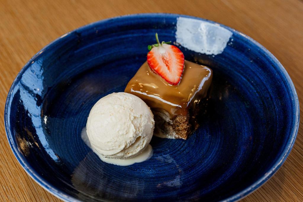a blue plate with a piece of cake and ice cream at Holiday Inn Express Aberdeen Airport by IHG in Dyce