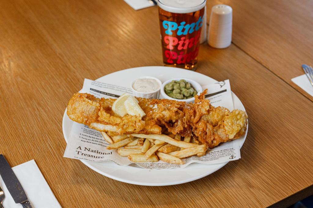 a plate of fish and french fries and a drink at Holiday Inn Express Aberdeen Airport by IHG in Dyce