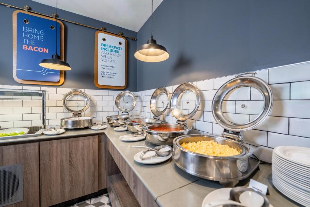 a kitchen with many bowls of food on a counter at Holiday Inn Express Aberdeen Airport by IHG in Dyce