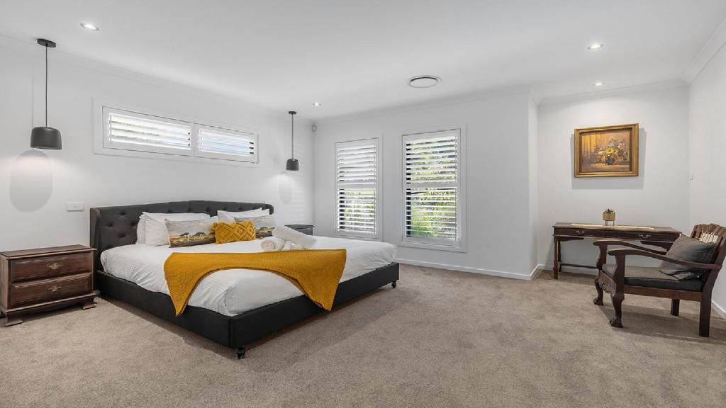 a bedroom with a bed and a desk and a chair at The Modern Vintage in Pokolbin