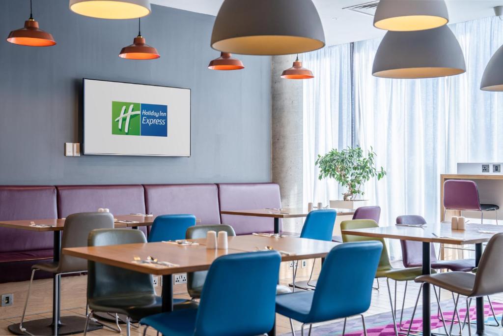 a meeting room with tables and blue chairs at Holiday Inn Express Aberdeen Airport by IHG in Dyce
