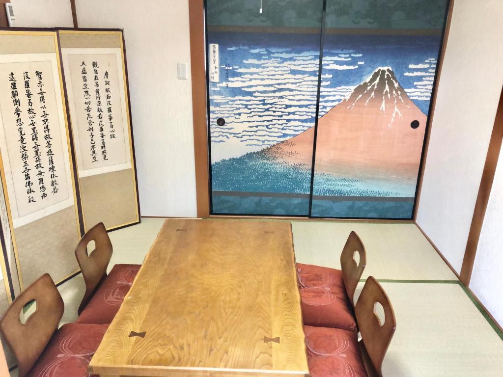 a table and chairs in a room with a mountain at HOKUSAI-KAN Osaka Taisho in Osaka