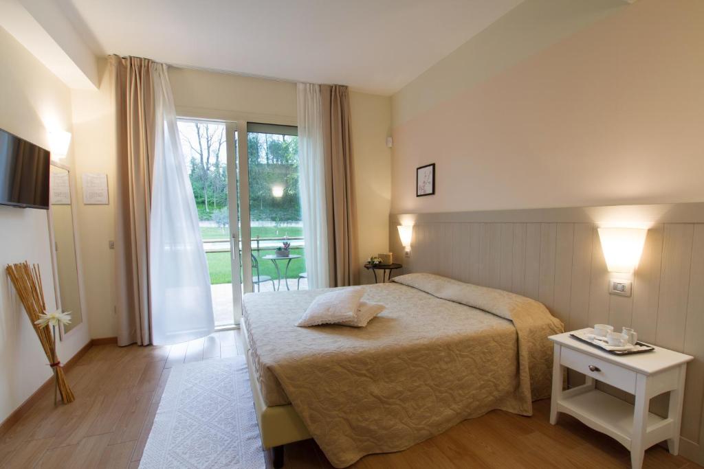 ein Schlafzimmer mit einem Bett und einem großen Fenster in der Unterkunft Agriturismo Ai Prati in Lazise